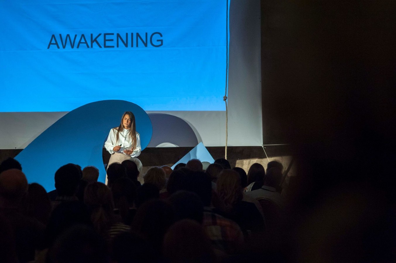 Natasha speaking on stage at TEDx